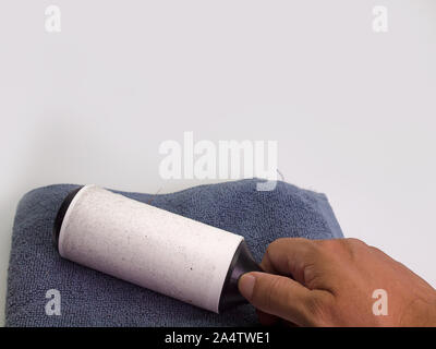 a man hand with  holding a white sticky brush for cleaning clothes Stock Photo