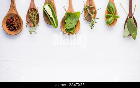Various of spices and herbs on wooden background. Flat lay spices ingredients rosemary, thyme, oregano, sage leaves and sweet basil on white wooden. Stock Photo