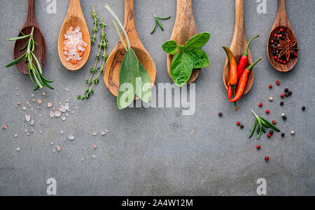 Various of spices and herbs in wooden spoons. Flat lay spices ingredients chili ,peppercorn, rosemarry, thyme,star anise ,sage leaves and sweet basil Stock Photo