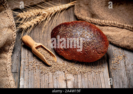 Bread rye spikelets. Freshly baked traditional bread on wooden table. Stock Photo