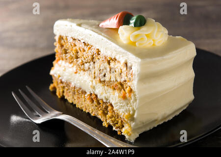 Sweet carrot cake slice on a plate on wooden table Stock Photo