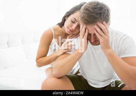 young couple handsome man and young woman feeling upset sitting on the bed Stock Photo