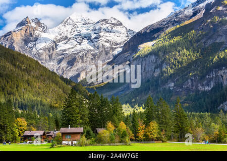 Colorful wooden houses in Kandersteg village, Canton Bern, Switzerland, Europe and snow mountains panorama Stock Photo