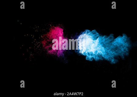 Abstract blue pink dust explosion on black background. Freeze motion of blue pink powder splash. Stock Photo