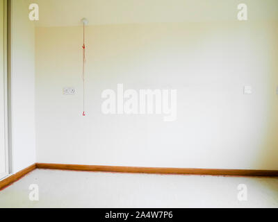 Vacant care home room with emergency alarm pull cord against wall. Stock Photo