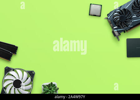 Computer parts on green desk composition. Free space in the middle for text. Stock Photo