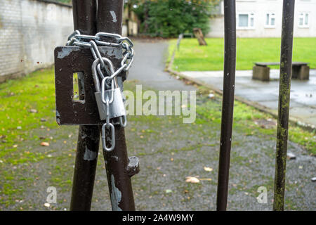 A gate is secured shut with a padlock and chain. Stock Photo