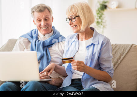 E-Commerce. Mature couple using laptop and credit card Stock Photo