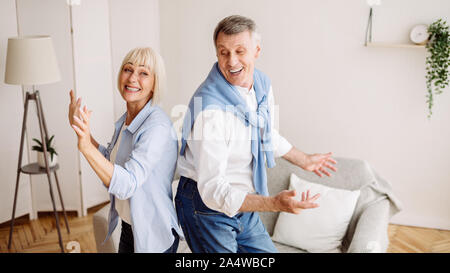 Joyful elder couple dancing at home, having fun Stock Photo