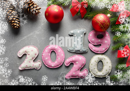 Colorful stitched digits 20 20 19 of polkadot fabric with Christmas decorations flat lay on stone background Stock Photo