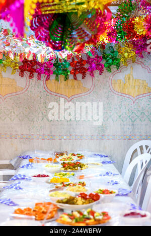 Colorful Sukkah decoration shiny garland and table. Happy family celebrate Sukkot. Stock Photo