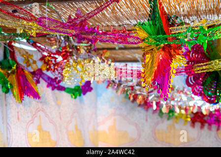 Traditional Sukkah for the Jewish Holiday Sukkot. Colorful Suka decoration shiny garland at sunset light. Stock Photo