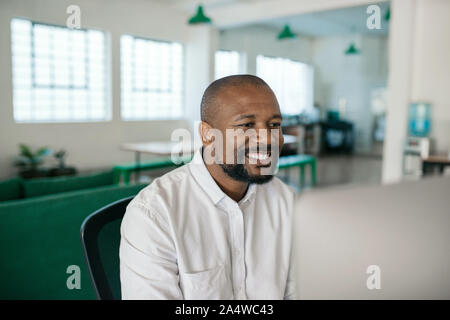Smiling African American businessman using a computer in an office Stock Photo