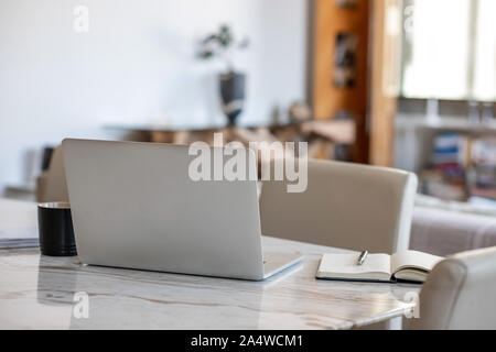Laptop and notebook sitting on an apartment table Stock Photo