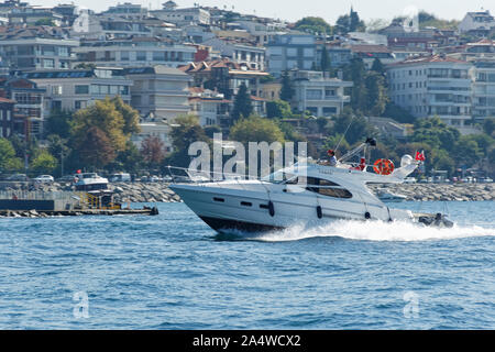 Power boat taxi in Bosphorus Strait moving fast and splashing water. Anatolian Site of Istanbul and buildings in the background. Stock Photo