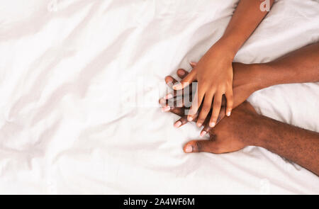 Black family of three stacking hands together over white background Stock Photo
