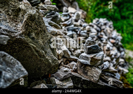 Ancient Tibetan Text Engraved on Slabs of Stone Scattered Over the Grass-Covered Lands of Yading Natural Conservation Area of Sichuan, China Stock Photo