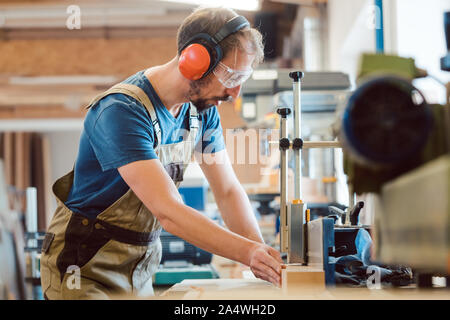 Absorbed carpenter at the milling machine working on wood Stock Photo