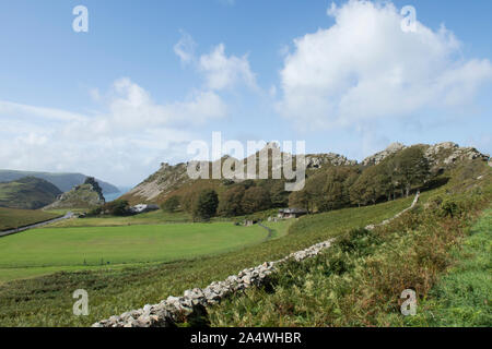 landscape view down through the Valley of Rocks over the cricket pitch to Castle Rock, Lynton, Devon. Stock Photo