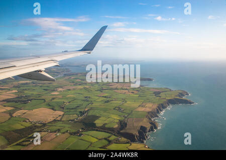 looking out of aircraft window over coastal cliffs on the east coast of Ireland Stock Photo