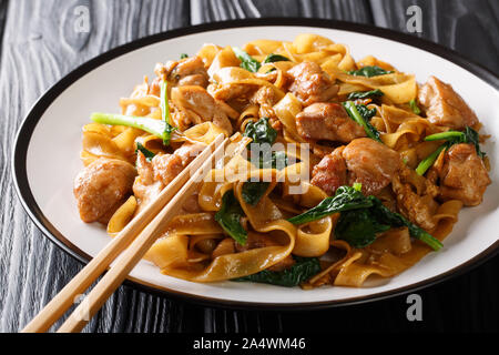 Fried rice noodles with chicken, Chinese broccoli and egg close-up on a plate on the table. horizontal Stock Photo