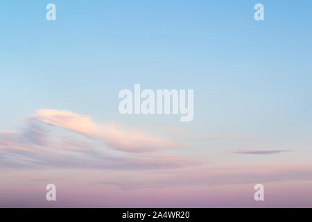 Sweet sky. Pink clouds in a blue sky at evening. Sky and clouds tranquil background with a pastel colors. Beauty in nature. Stock Photo