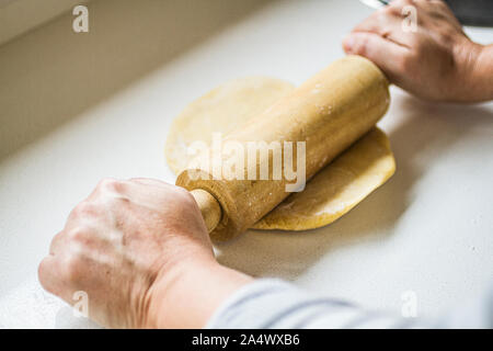 Detail of hands of a woman rolling dough with a rolling pin. Florianopolis, Santa Catarina, Brazil. Stock Photo