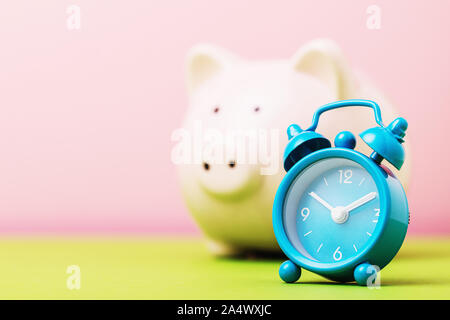 Alarm clock and piggy bank with copy space, close-up. Concept - time to save money Stock Photo