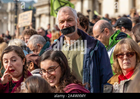 Trafalgar Square, London, UK. 16th Oct 2019. Extinction Rebellion demonstrator with mouth taped at Trafalgar Square climate change protest Credit: Ricci Fothergill/Alamy Live News Stock Photo