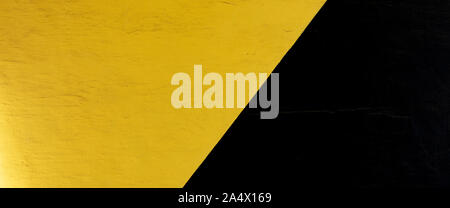Old yellow and black painted plastered wall banner background Stock Photo