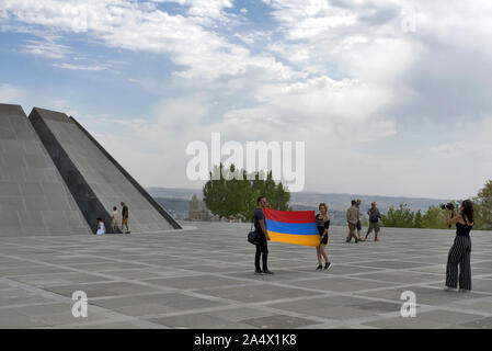 Erevan/Yerevan, Armenia, 2019: Armenian Genocide Memorial - Zizernakaberd, Tsitsernakaberd with people with armenian flag in front of it Stock Photo