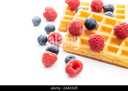 Waffles with blueberries and raspberries isolated on white background. Stock Photo