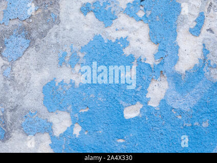 Close-up of a weathered and old concrete wall, light blue paint is peeling off. High resolution abstract full frame textured background. Stock Photo