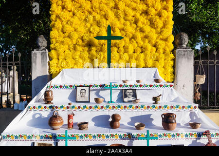 Merida, Mexico - 31 October 2018: Flower altar with cross and offerings for day of the dead, tradition for dia de los muertos in Calle 66 Stock Photo