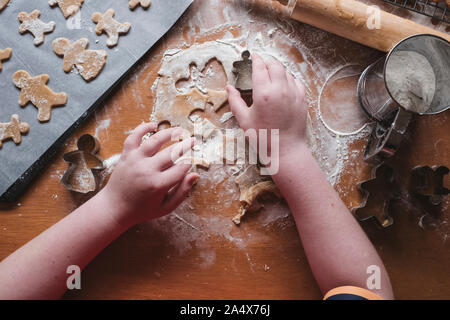 Boy cutting out gingerbread from dough Stock Photo