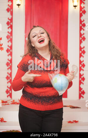 an emotional adult woman holds a planet in a plastic bag in her hands and shows irresponsible excessive consumer plastic. Stock Photo