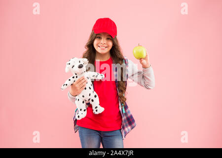 Apple is good source of vitamin C. Happy small child hold vitamin fruit on pink background. Little girl with healthy vitamin snack. Benefits of eating vitamin food for kids activity. Stock Photo