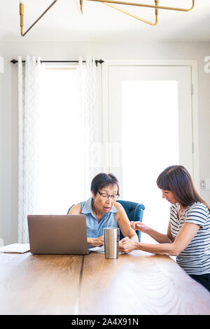 Daughter Explaining Paperwork To Mother Stock Photo