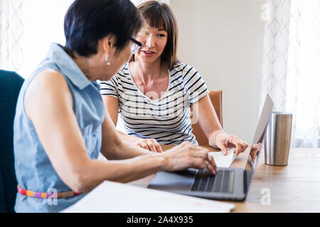 Daughter Explaining Computer to Mother Stock Photo