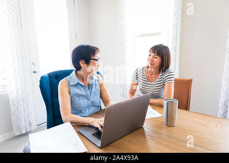 Family Business Owner Working With Daughter on Bills Stock Photo