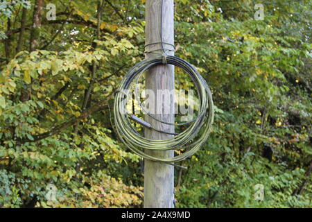 Rolled up cable with moss on it tied to a old wooden mast, selected focus on cable Stock Photo