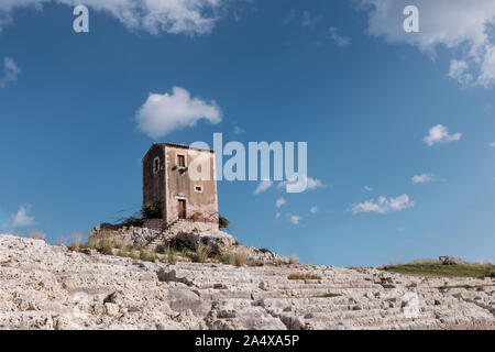 Siracusa, Sicilia, Italy - December 8 2019: Galerme windmill with the seats of the greek theater of Siracusa as foreground and blue sky as background Stock Photo