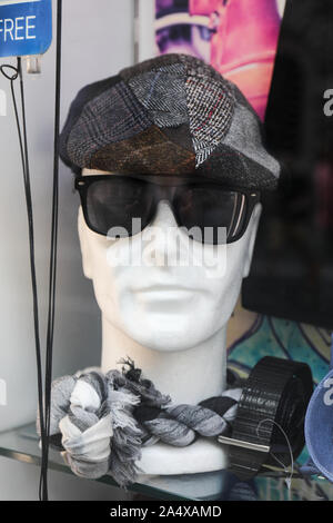 Male styrofoam mannequin head with cap, sunglasses and scarf in a display window Stock Photo