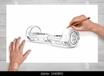 Male hands drawing a self-balancing board on white paper with a pencil in close view. Stock Photo
