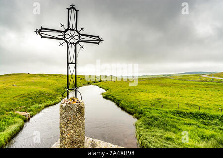 An iron cross was erected on a bridge of the pilgrimage way to santiago de Compostela. It dominates the river Bes which flows on the Aubrac plateau Stock Photo