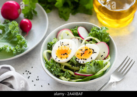 Healthy salad with egg, radish, kale and cucumber in bowl. Diet fresh spring salad Stock Photo