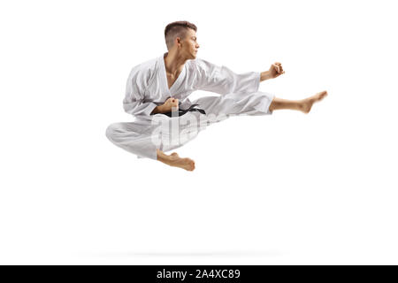 Young man in karate kimono jumping and kicking isolated on white background Stock Photo