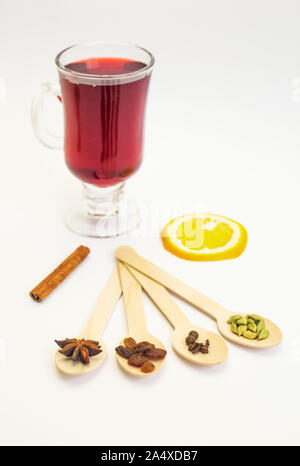 Mulled wine ingredients. Cinnamon, orange, cardamom, clove, anise and red wine on white background. Composition of traditional winter drink. Stock Photo