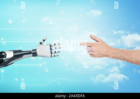A human hands reaches to the white and black very detailed robotic hand on blue background. Stock Photo