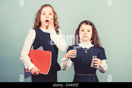 shocked about results. little smart girls with testing flask. biology education. children study chemistry lab. school kid scientist studying science. back to school. girls with folder. feel shocked. Stock Photo